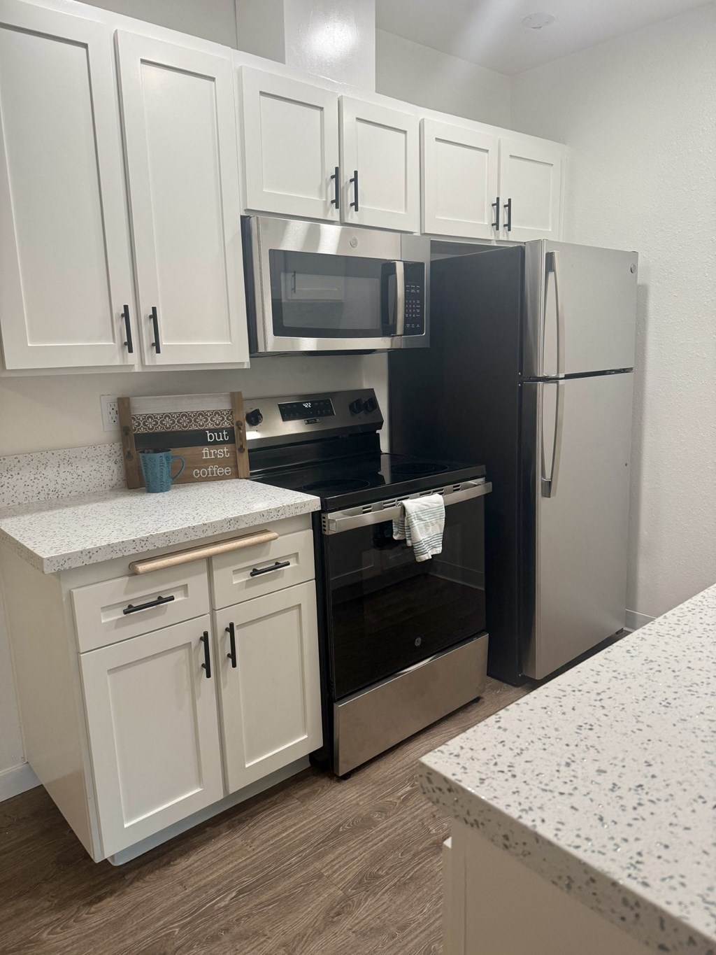 A kitchen with black appliances and white cabinets. at Camino de Oro Apartments, Torrance, CA, 90505