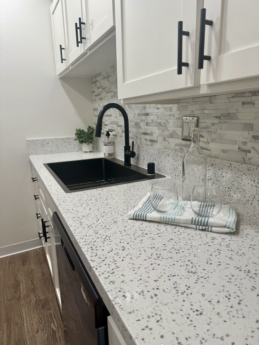 A kitchen with a black sink and a white speckled countertop. at Camino de Oro Apartments, Torrance, CA, 90505