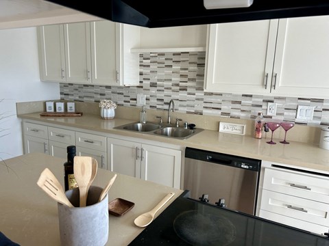 A kitchen with a black stove top oven and a white counter top.