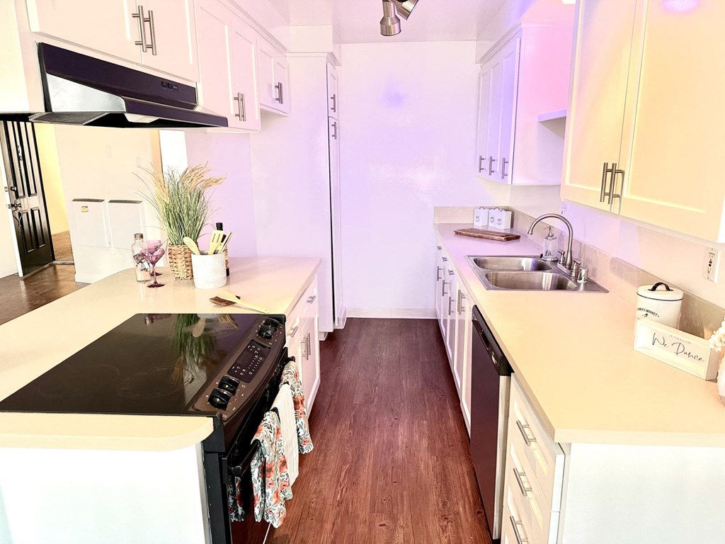 A kitchen with a black stove top oven and white cabinets at Royal Towers Apartments, Redondo Beach, CA, 90277