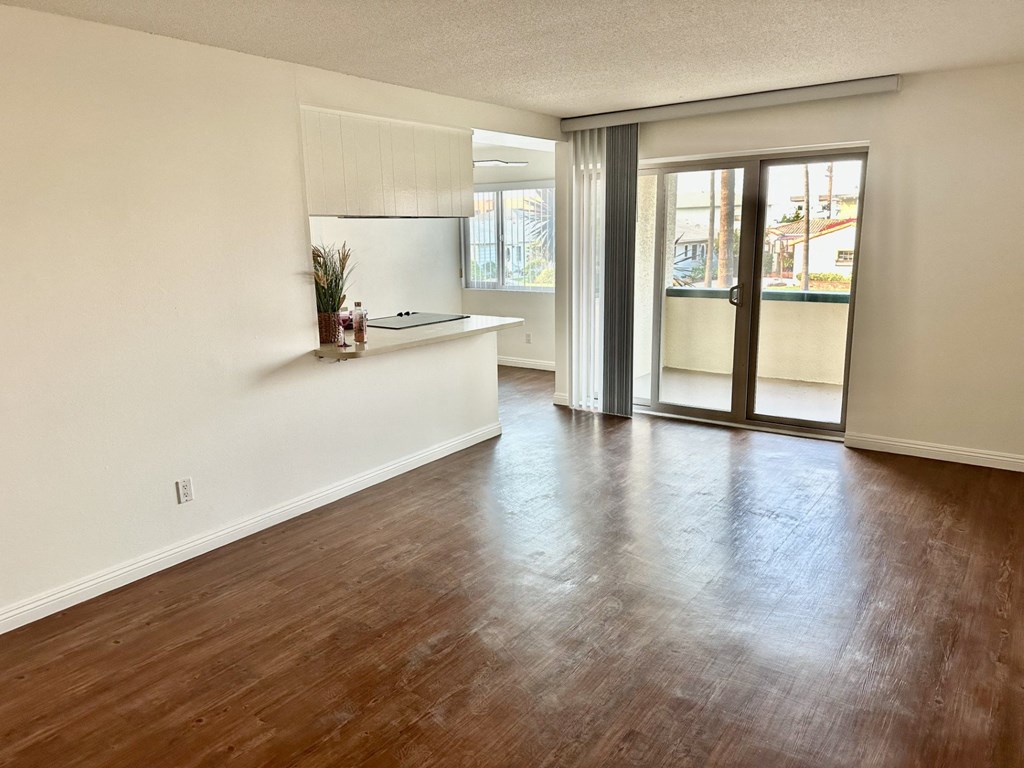 A room with wooden floors and a window with blinds at Royal Towers Apartments, Redondo Beach, CA, 90277