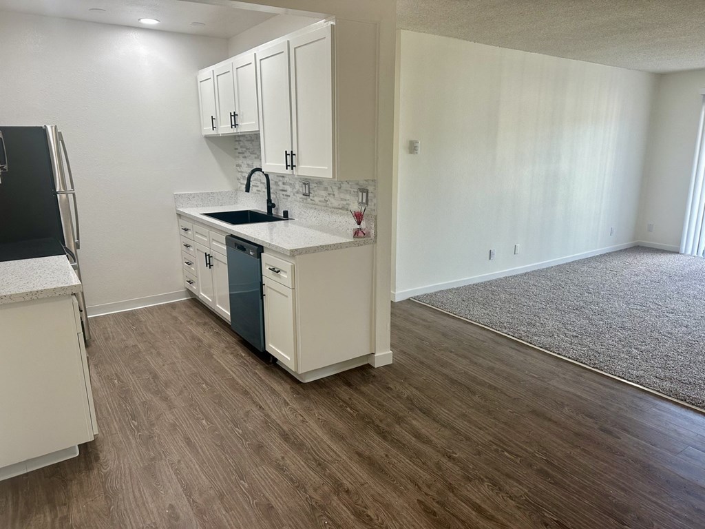 A kitchen with white cabinets and a black fridge. at Camino de Oro Apartments, Torrance, CA, 90505