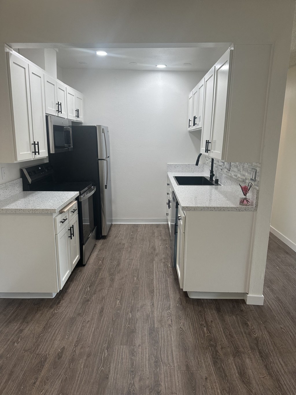 A kitchen with white cabinets and a black fridge. at Camino de Oro Apartments, Torrance, CA, 90505