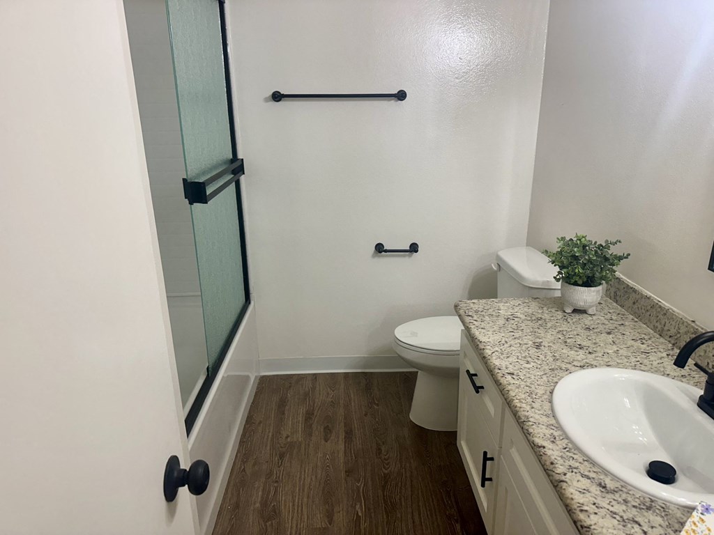 A bathroom with a toilet, sink, and shower.