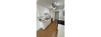 A kitchen with white cabinets and a black stove top oven.
