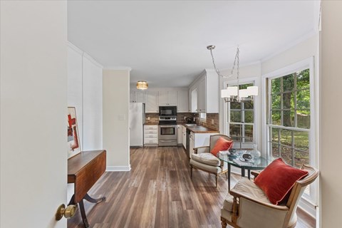 A kitchen with a dining table and chairs.