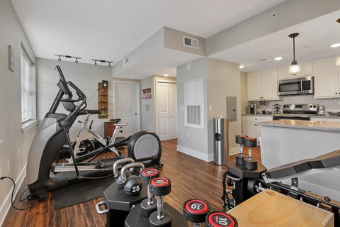 A home gym with a treadmill, weights, and exercise equipment.