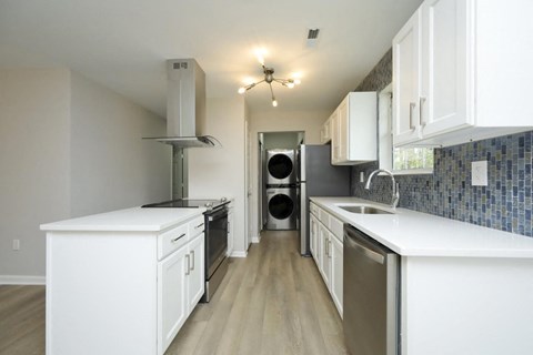 A kitchen with white cabinets and a tile backsplash.