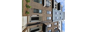 A modern building with a mix of brick and panel construction.