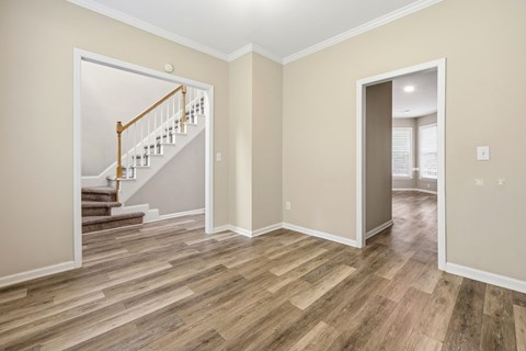 A room with a wooden floor and a staircase.