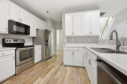 A kitchen with white cabinets and stainless steel appliances.
