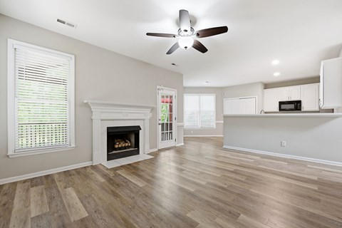 A living room with a fireplace and a ceiling fan.