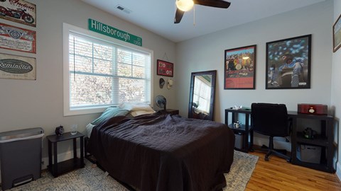A bedroom with a bed, desk, and chair.