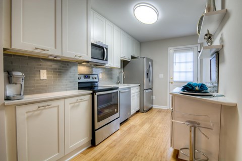 A kitchen with white cabinets and stainless steel appliances.