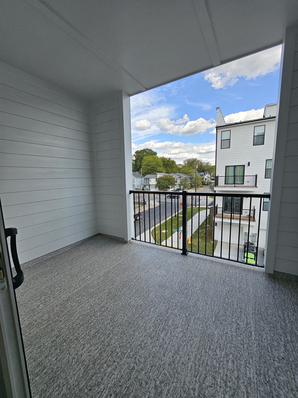 the view from the balcony of an apartment living room with a view of the yard