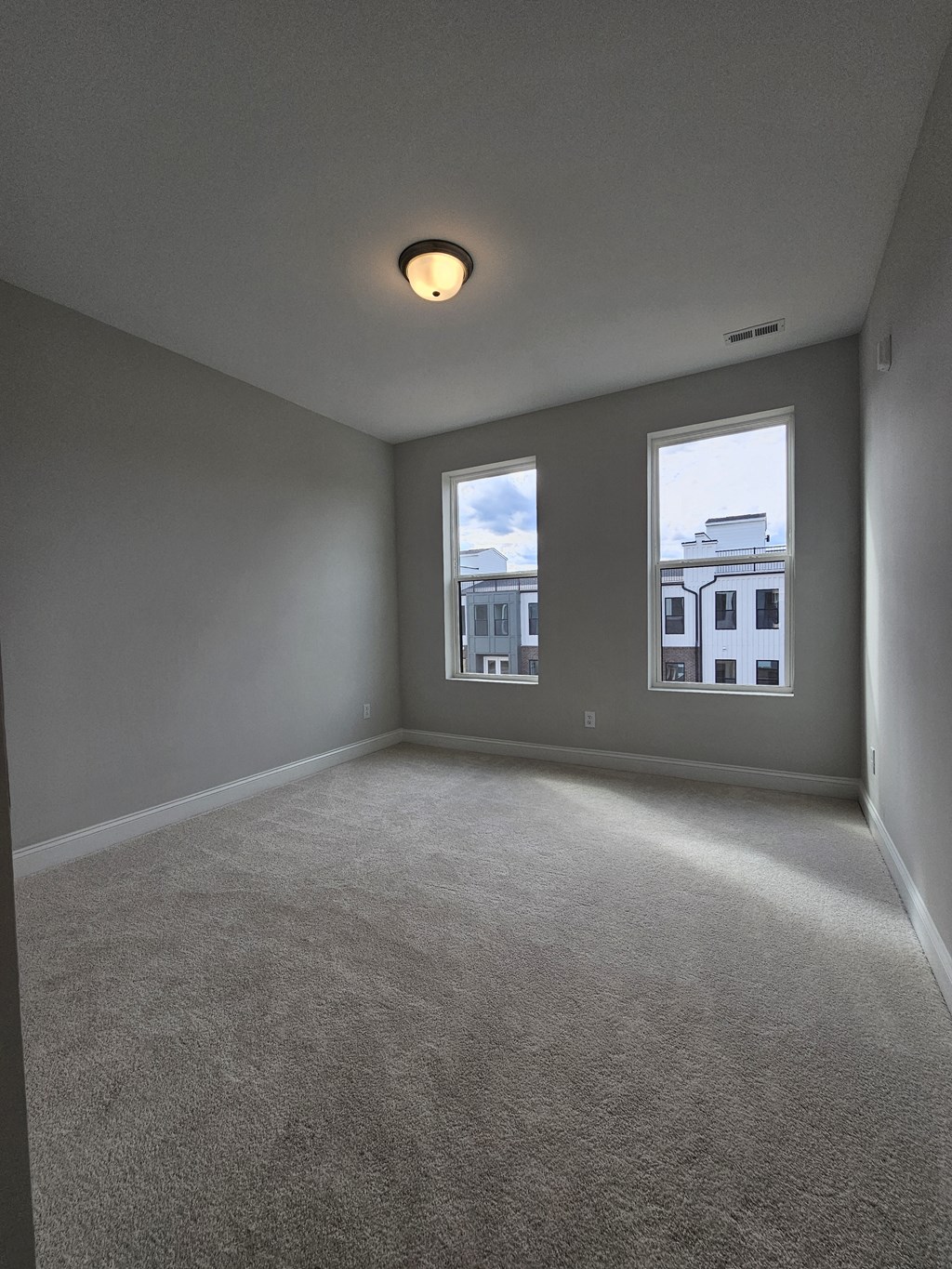 an empty living room with two windows
