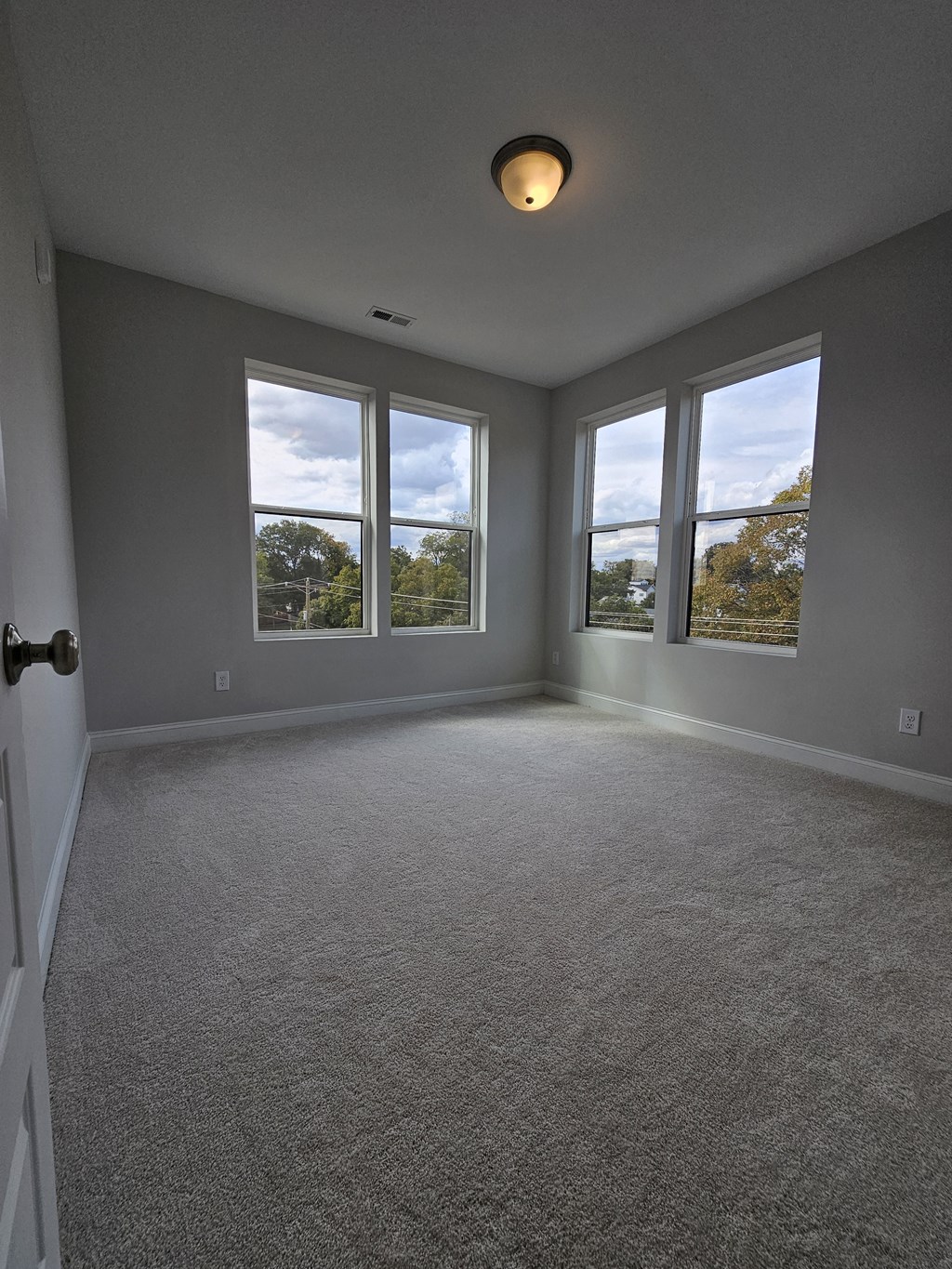 an empty living room with three windows