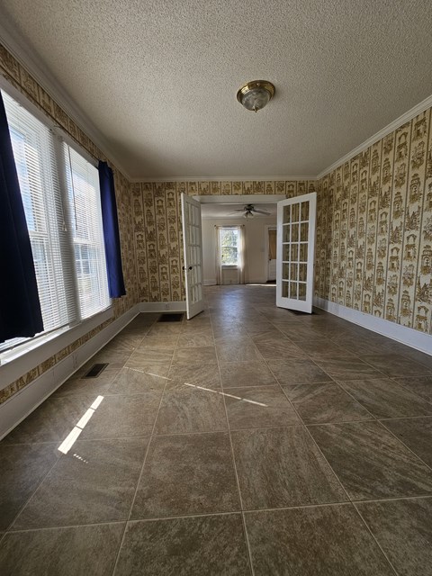A room with a tiled floor and patterned wallpaper.