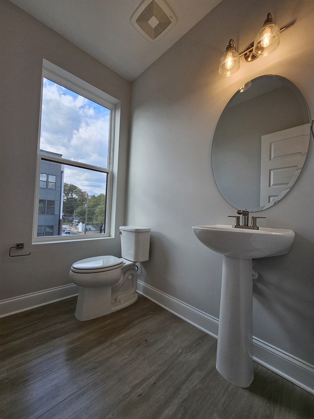 a bathroom with a toilet and a sink and a window