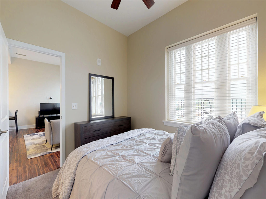 A bedroom with a large bed and a mirror on the wall.