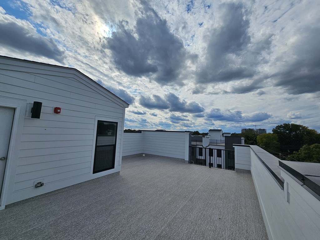 a view of the roof of a building with clouds in the sky