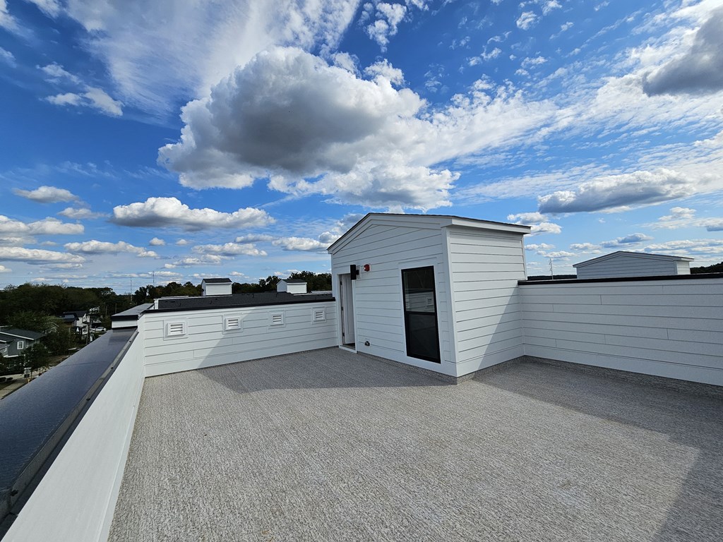 a view from the roof of a white building with a blue sky