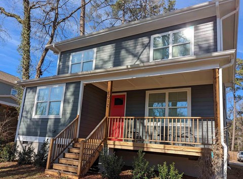 A house with a red door and a balcony.