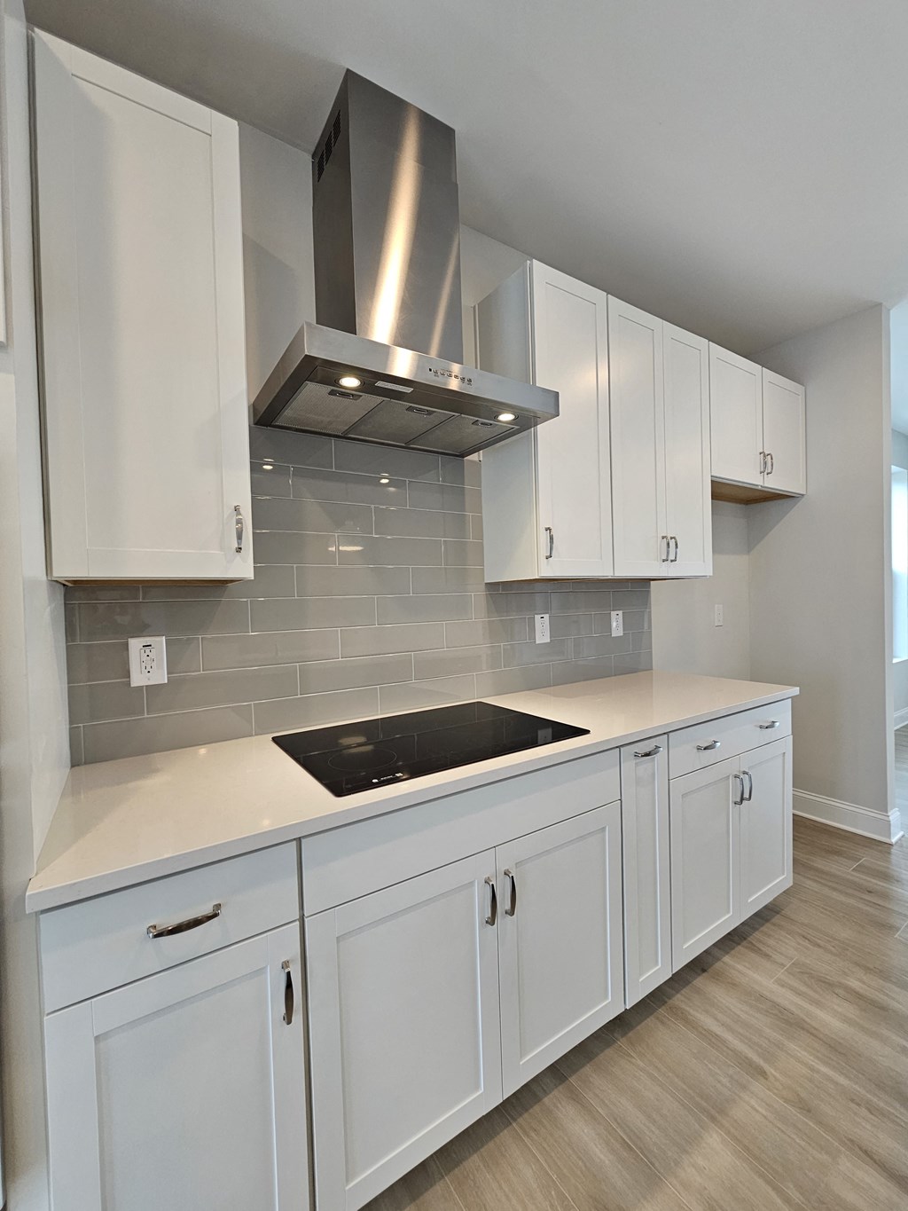 an empty kitchen with white cabinets and a stove