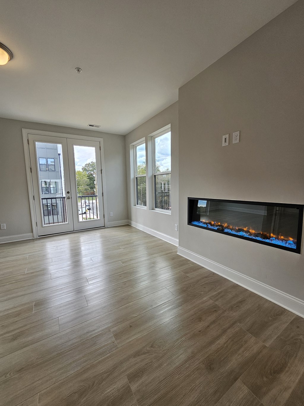 a living room with a fireplace and a door to a balcony
