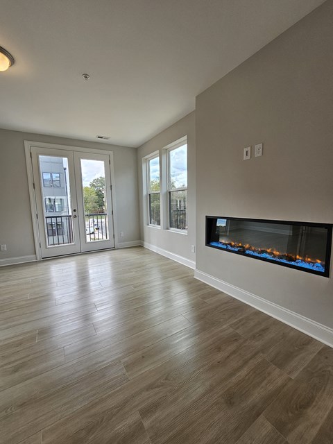 a living room with a fireplace and a door to a balcony