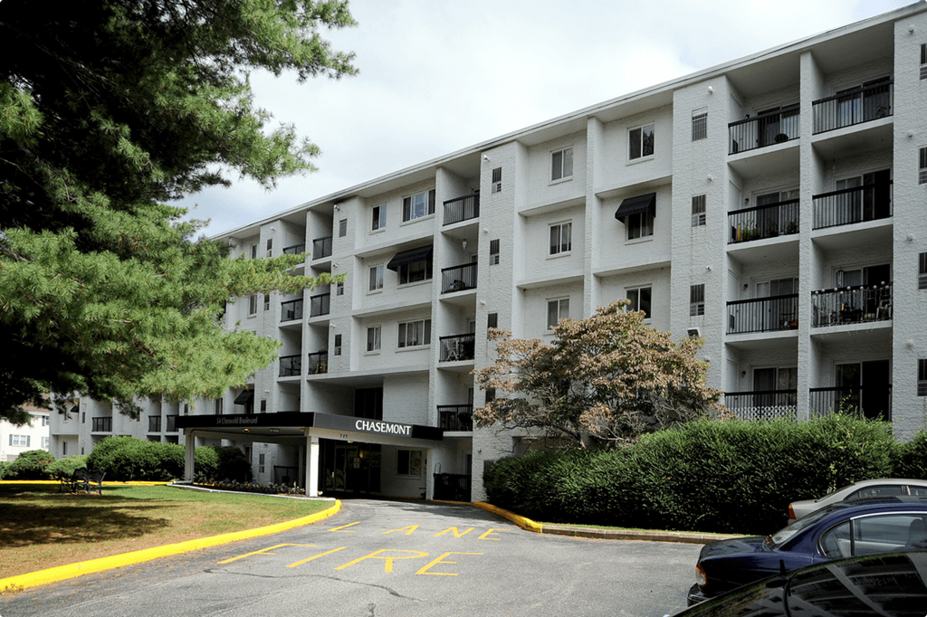 a large apartment building with cars parked in front of it