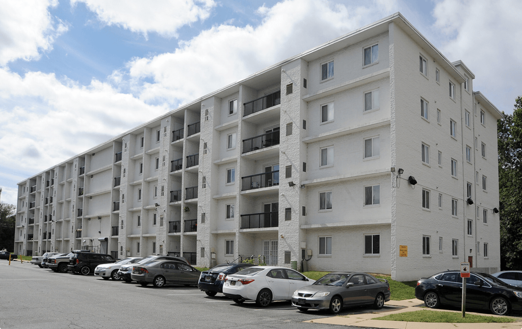 a white apartment building with cars parked in front of it