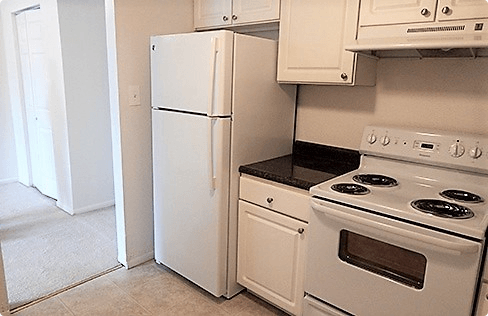 a kitchen with white appliances and a refrigerator