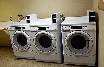 two washing machines sitting next to each other in a laundromat