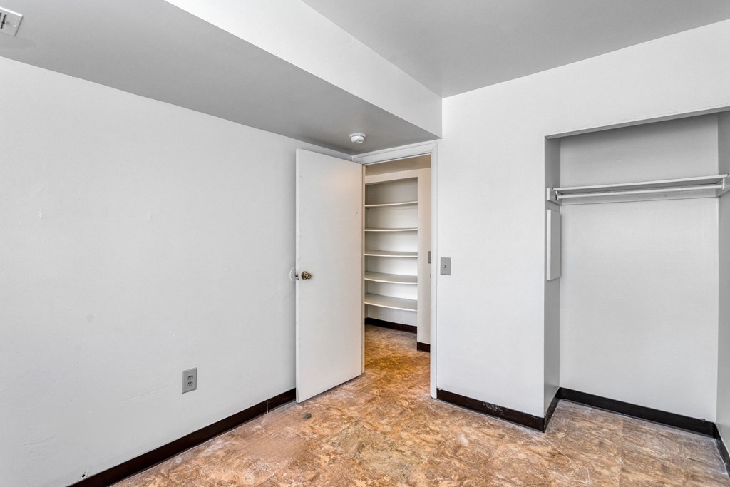 an empty room with white walls and a closet with a door