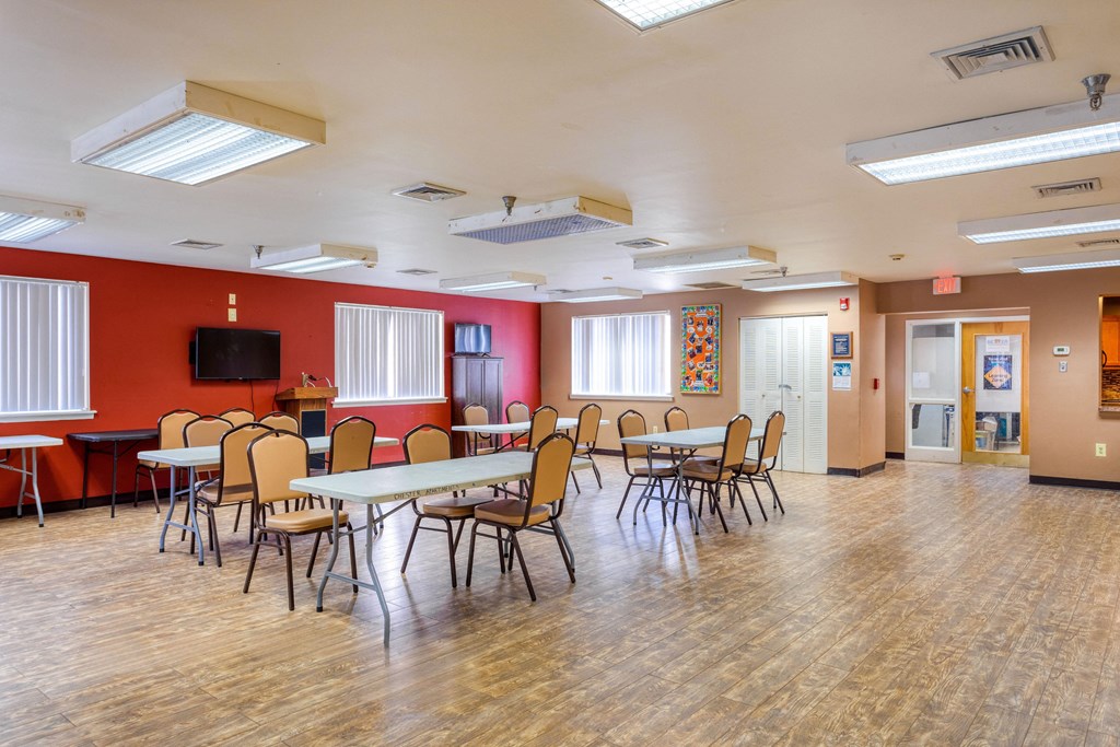 a multipurpose room with tables and chairs and a tv