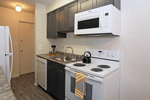 a kitchen with white appliances and a sink and a white microwave