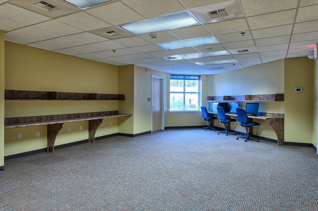 a large room with desks and chairs and a window
