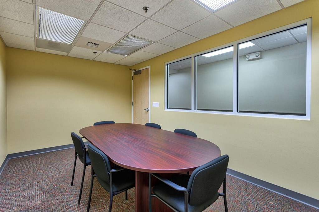 a conference room with a wooden table and chairs