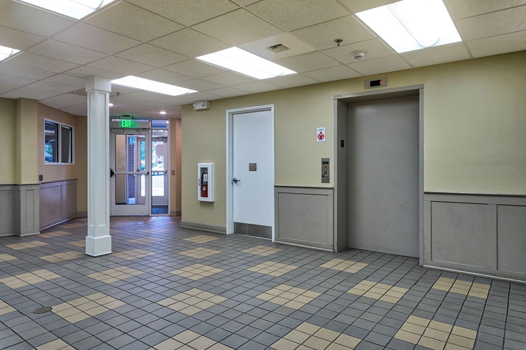 the lobby of a building with doors and a tiled floor