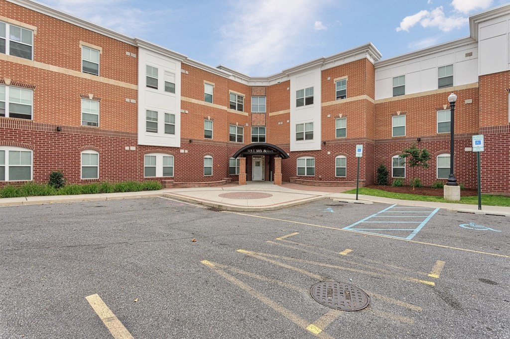 an empty parking lot in front of a brick building