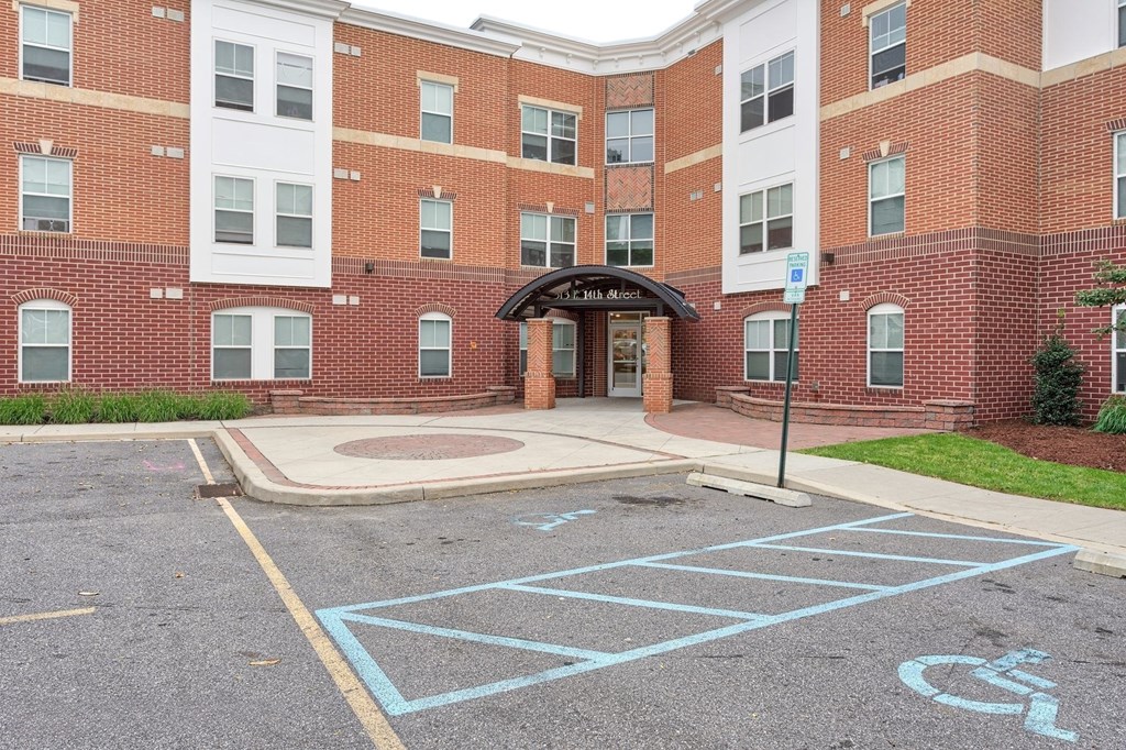 the entrance to a brick building with a handicapped parking lot