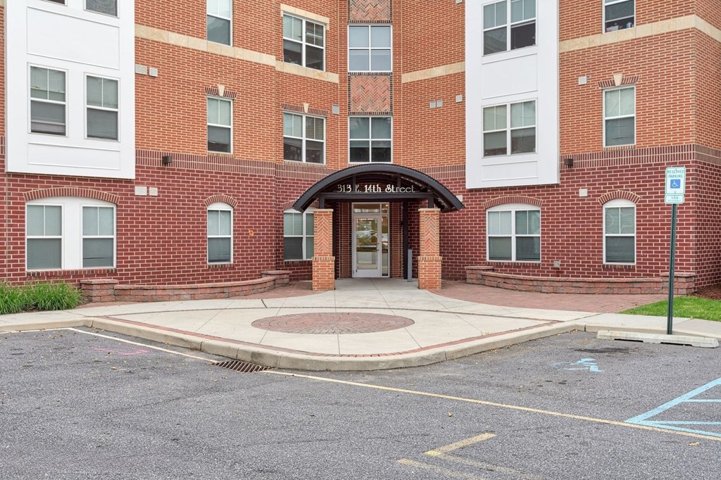 the entrance to a brick building with a sidewalk in front of it