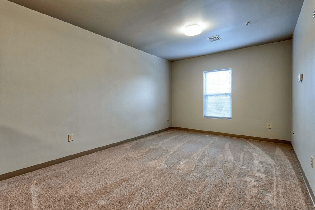 the living room of an empty house with a window