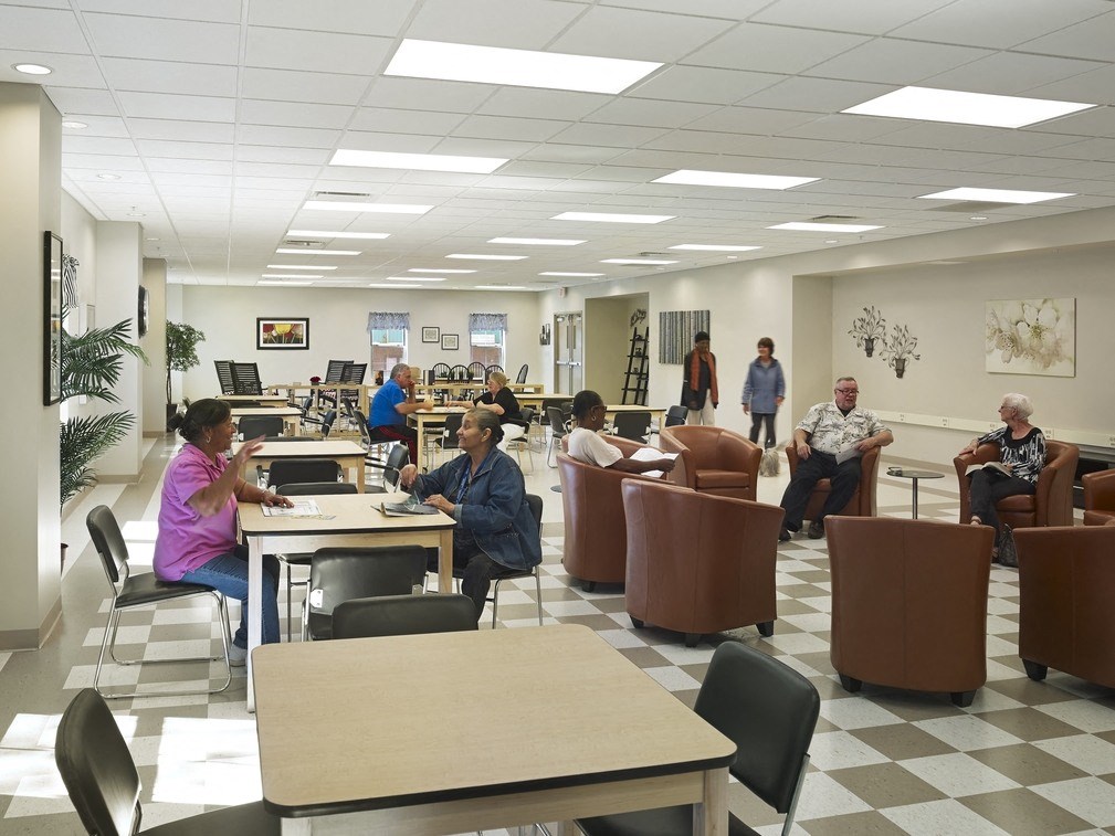 people sitting at tables and chairs in a library
