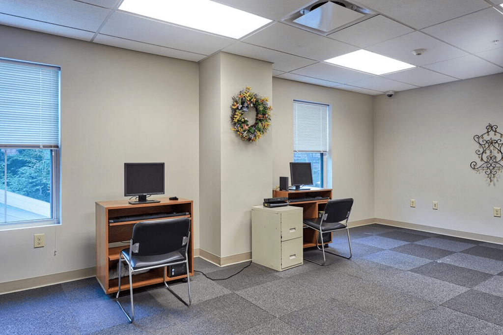 a room with two desks and two chairs and a television