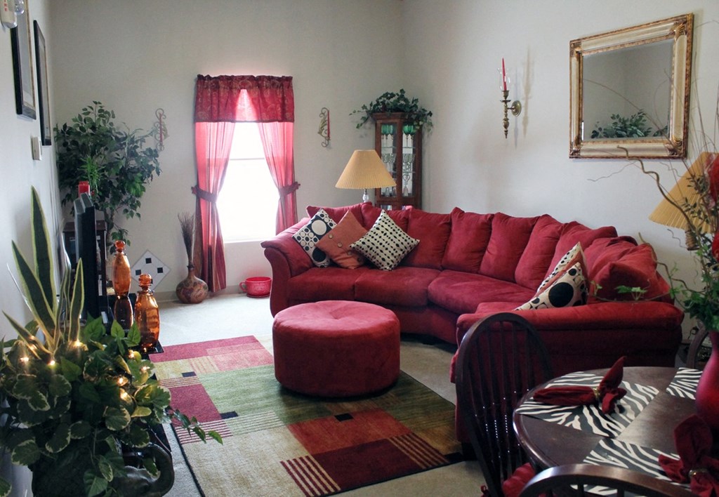 a living room with a red couch and a christmas tree
