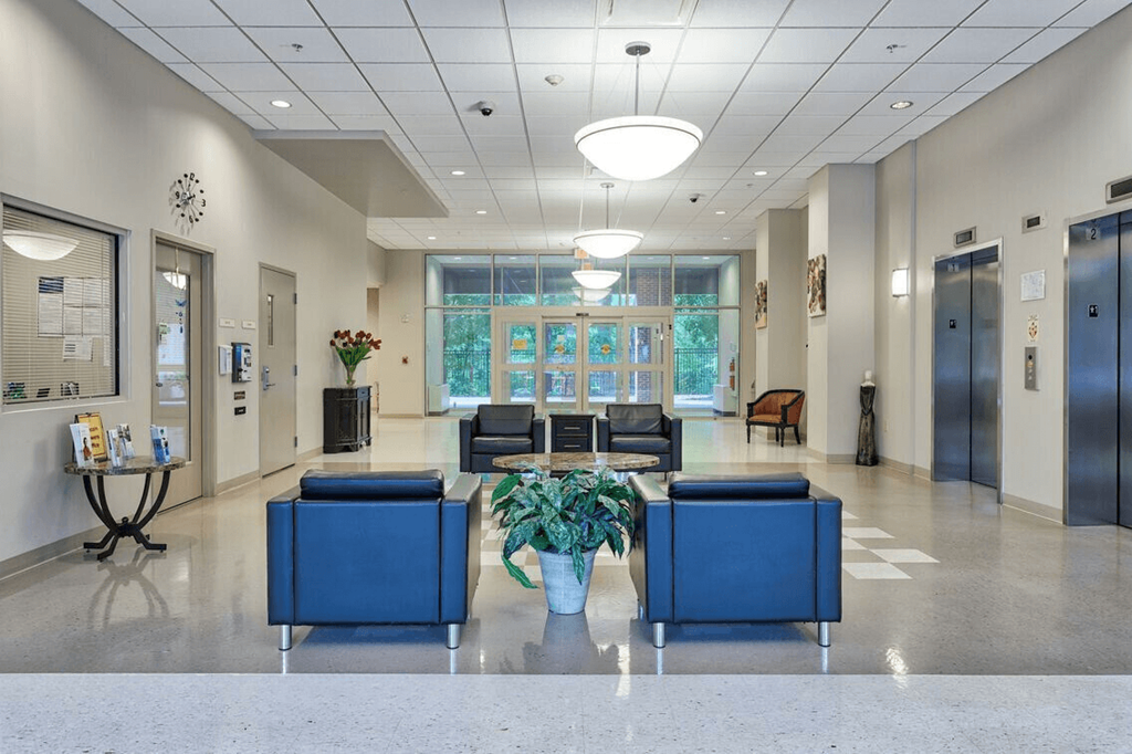 a lobby with blue couches and chairs and a table with a plant