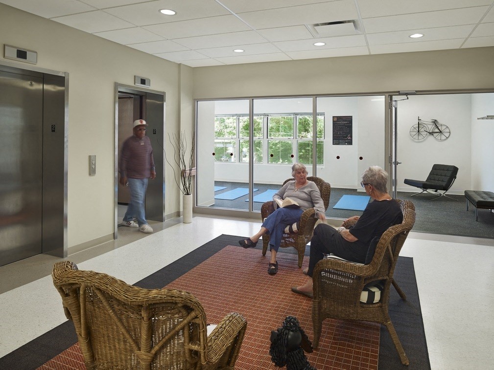 a group of people sitting in chairs in an empty waiting room