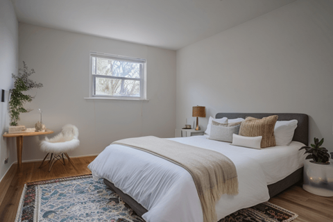 a bedroom with a bed and a chair and a window